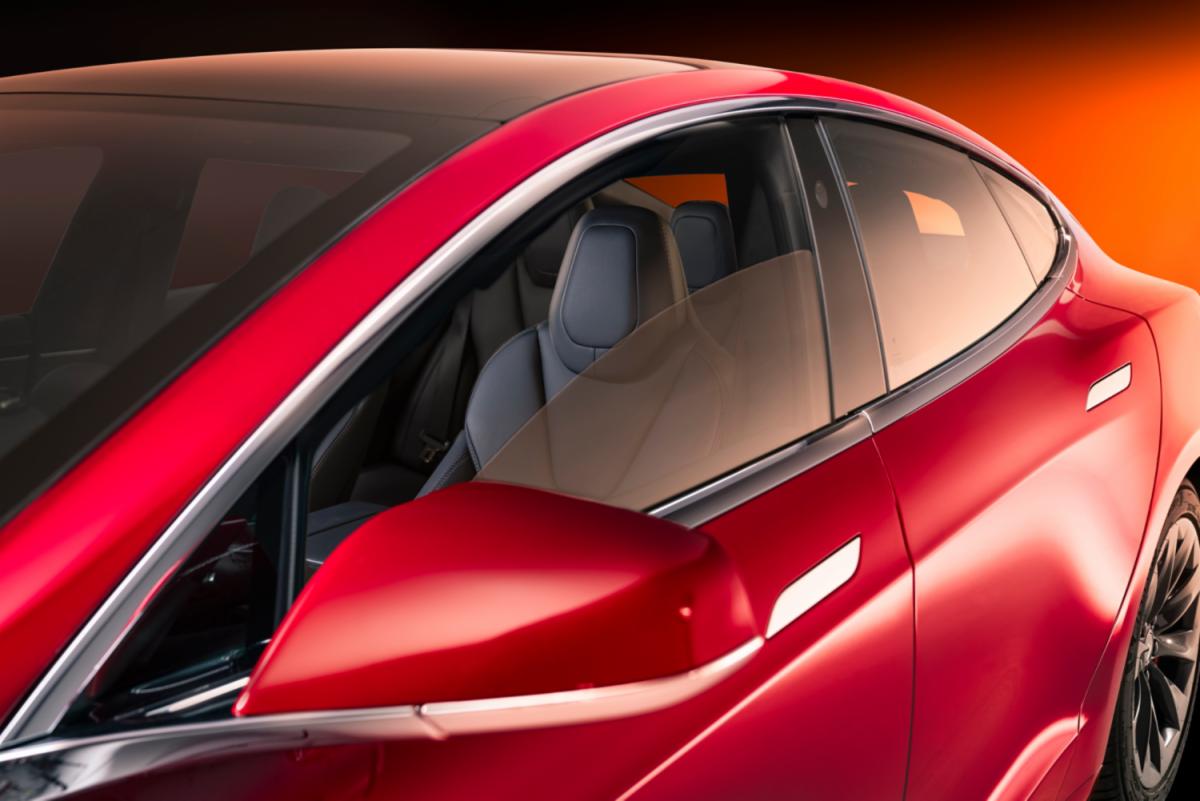 3M automotive window-film promotional image showing the side windows of a red car.